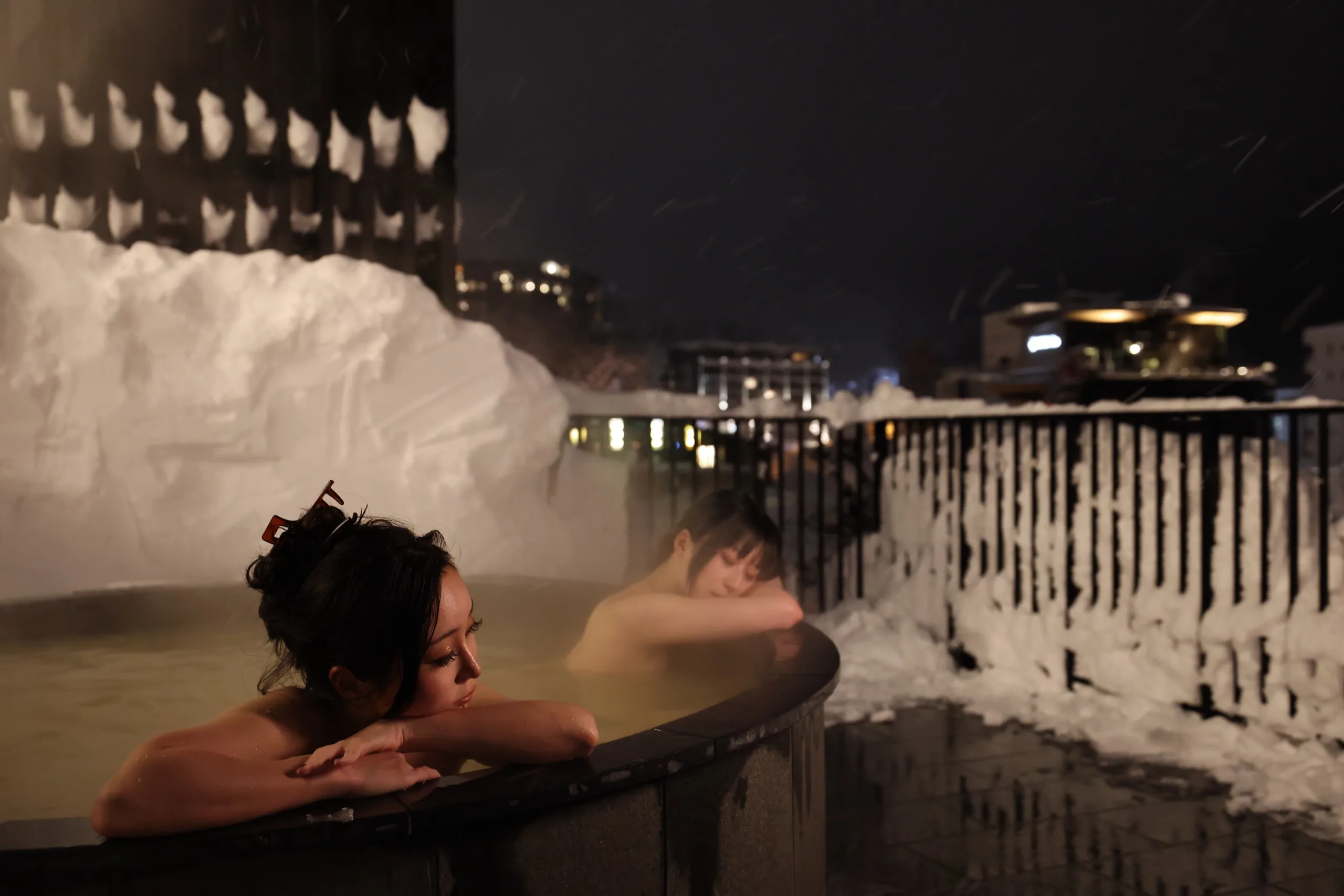 Guests enjoying the outdoor onsen surrounded by snow